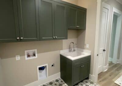 Laundry room with green cabinets Canton GA custom home